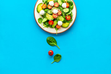 Healthy lunch. Fresh vegetable salad on blue background top view copy space