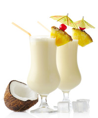Pina colada cocktails with coconut and ice cubes isolated on white