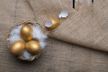 Success Symbol or Happy Easter Concept. Empty Broken Big Golden Egg on a rustic wooden natural background