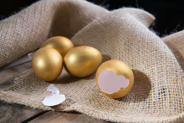 Success Symbol or Happy Easter Concept. Empty Broken Big Golden Egg on a rustic wooden natural background