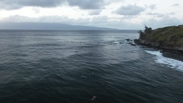 Wide aerial, surfers await waves in Honokahua Bay, Hawaii
