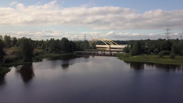 Flying over beautiful landscape a large automobile bridge over the lake, forest.