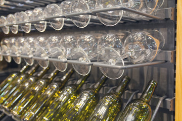 Glasses and bottles on a rack in the wine cellar. Alcohol