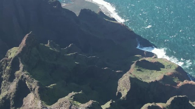 Aerial, mountains near water at Na Pali Coast State Park in Hawaii