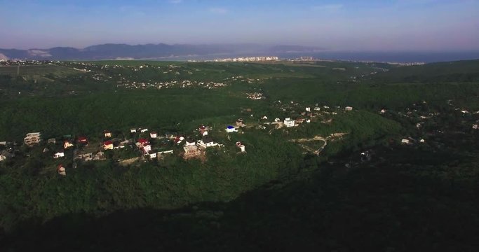 Aerial view of village houses and hills