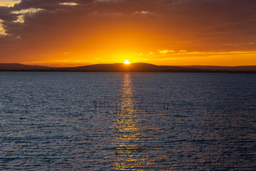 coucher de soleil flamboyant en orange avec montagne et mer