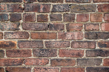 Brick industrial wall, excellent background. Color and detail in this beautiful vintage brick wall, built years ago. Cracked and aged surface of textured brick wall. 