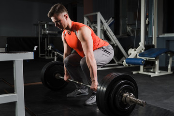 Strong handsome fit man exercising in the gym. Personal trainer workout. Athletic man working out...