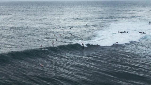 Surfers ride wave in Honokahua Bay, Hawaii, aerial