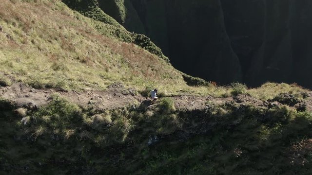 Man hiking atop mountain at Na Pali Coast State Park in Hawaii, aerial