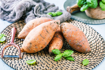 Fresh sweet potatoes on rustic background.