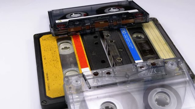 Four Audio Cassettes Rotate on White Background