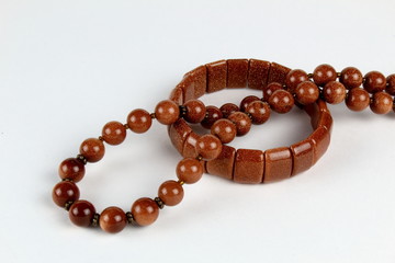 Beads and bracelet made of natural stone aventurine, on a light background.