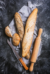 Fresh bread and knife on a black background. Top view with copy space