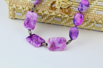 Beads made from natural stone sugilite,on a light background.