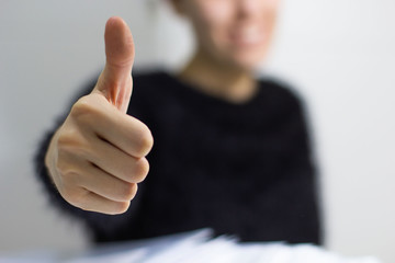 a young girl doing thumbs up symbol with his hand in a white background