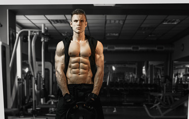 Fototapeta na wymiar Muscular model sports young man exercising in gym. Portrait of sporty healthy strong muscle. Fitness trainer. Sport workout bodybuilding motivation concept. Sexy torso.