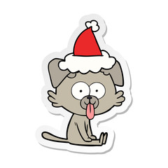 sticker cartoon of a sitting dog with tongue sticking out wearing santa hat