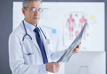 Male doctor writes notes on the clipboard in the hospital