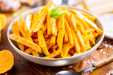 Fresh sweet potatoes on rustic background.