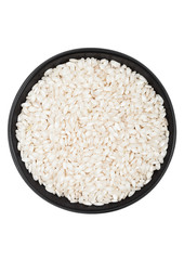 Black bowl of raw organic arborio risotto rice on white background. Healthy food.