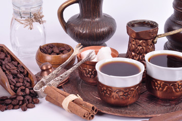 Coffee in copper coasters with accessories for coffee-drinking on a white background.