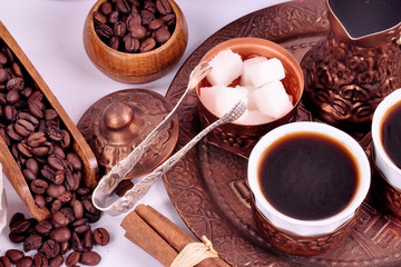Coffee in copper coasters with accessories for coffee-drinking on a white background.
