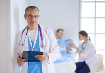 Doctor holding folder in front of a patient and a doctor