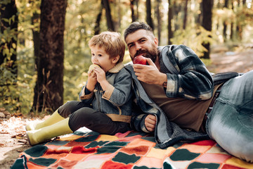 Little boy with his father in autumn outdoors. Man with son, dad with young son in autumn park....