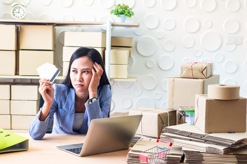 Young  Asia Businesswoman use laptop. She is use laptop for order online and show credit cards. She  is sad and unhappy.E-commerce , Shopping , Photo concept work and Business.