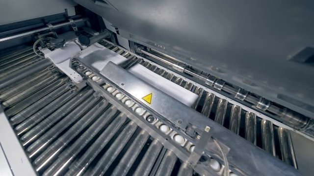Stacks of paper on an automated conveyor, close up.