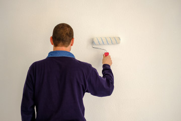 Man painting a white wall.