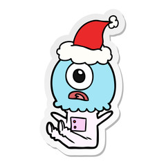 sticker cartoon of a cyclops alien spaceman wearing santa hat