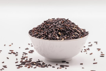 Rice berry in the white bowl in isolate white background.