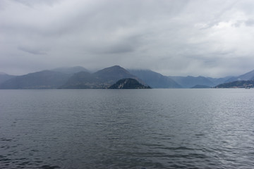 Fototapeta na wymiar Italy, Varenna, Lake Como, a large body of water with a mountain in the background