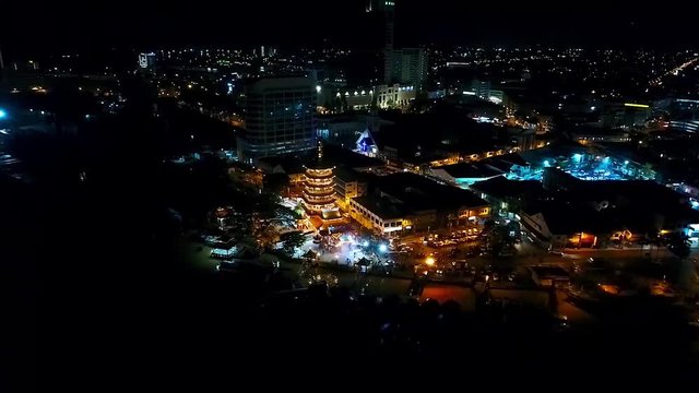 TOp Night View of a Chinese Temple next to sea In Kota Kinabalu - Malaysia - Aerial - backward Dolly 