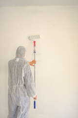 Man painting a white wall.