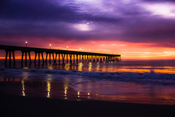 Fototapeta na wymiar Atlantic Ocean sunrise with pier and full moon