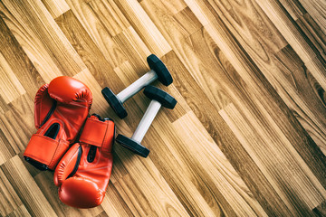 Red boxing gloves on wood background. Sport and healthy lifestyle concept.