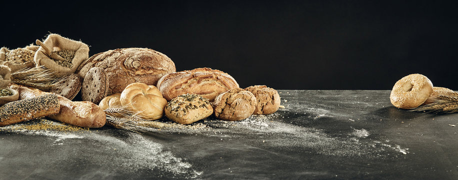 Table with bread assortment on black background