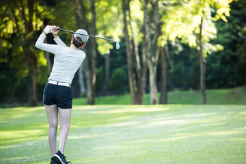 Asian woman playing golf on a beautiful natural golf course