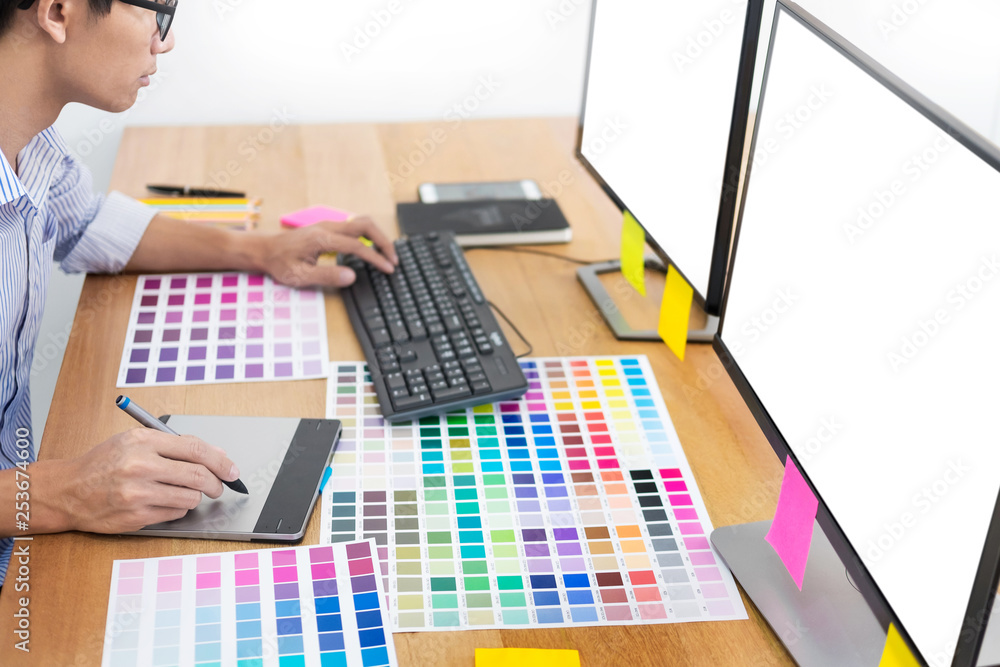 Aufkleber designer editor at work drawing sketches a new project on graphic tablet and color palette sitting a