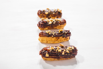 Food, bakery and desserts concept - row of eclairs on white background