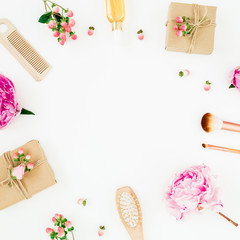 Creativity frame composition of pink peony with hairbrush, tassel and gifts box on white background. Flat lay