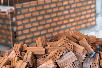 Stack of Brick preparing for mansonry over the photo blurred of Bricks wall background,