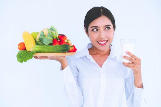 Woman nutritionist presenting diet food of fruit and vegetables for cholesterol control showing awareness and prevention of heart disease. Healthy eating and good nutrition concept.