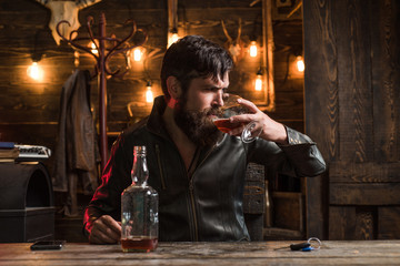 Man with beard holds glass brandy. Degustation, tasting. Handsome bearded man. Do not drink and drive.