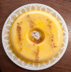 home made vanilla and cinnamon flan over a wooden table
