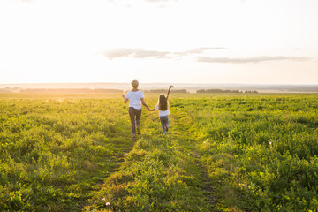 Family, summer and holiday concept - little daughter and mother run in the summer field