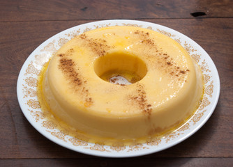 home made vanilla and cinnamon flan over a wooden table